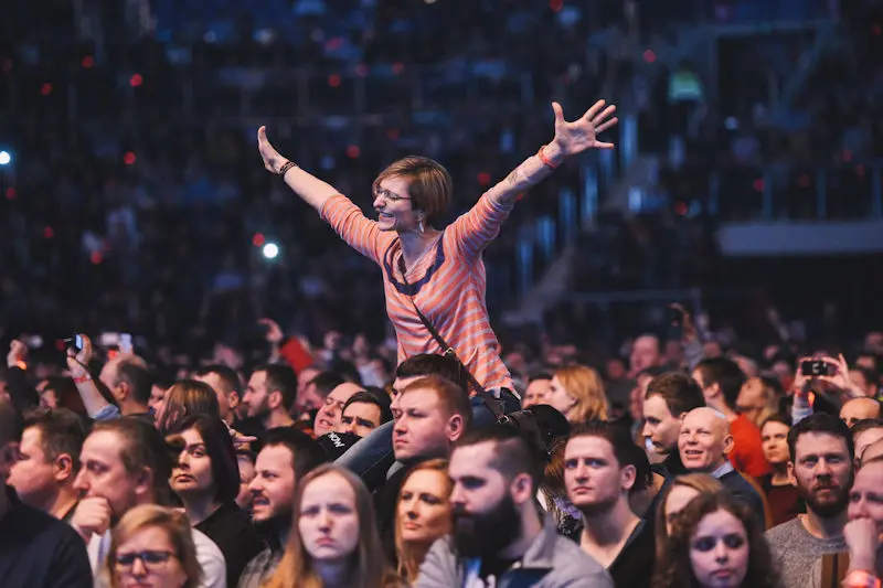 Woman with arms raised in crowd