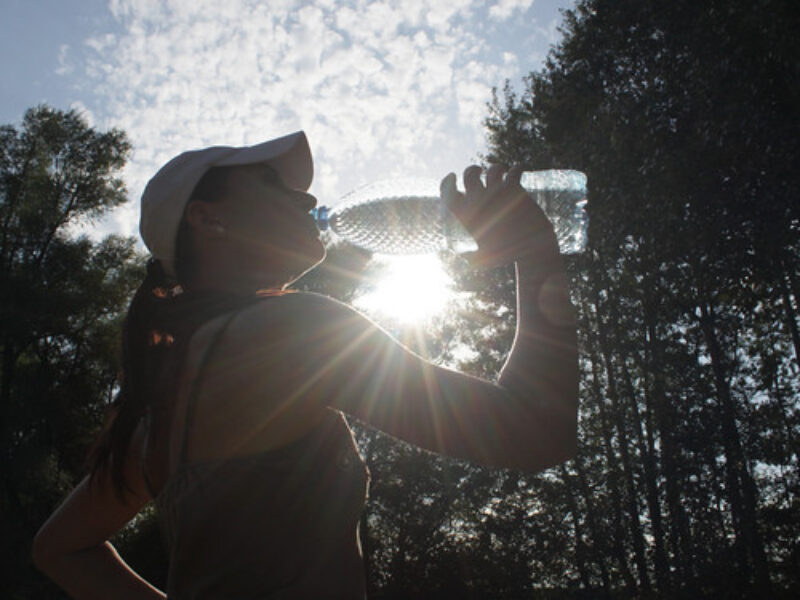 A woman resting at home and drinking a glass of water
